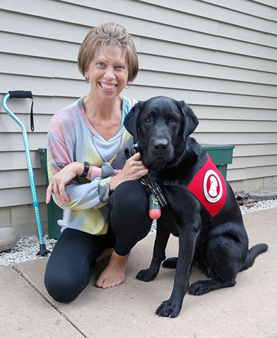 woman with black lab service dog