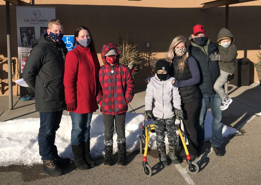 six people with facemasks in parking lot