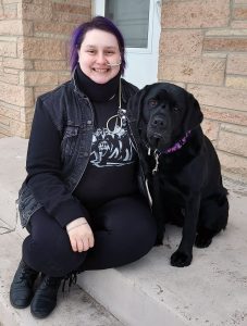 young woman and black dog sitting on front step