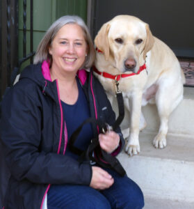 woman sitting on front steps with yellow lab