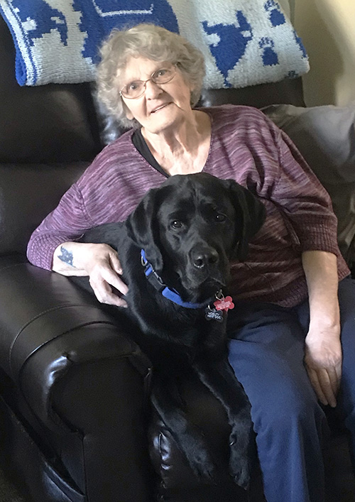 woman and large black dog sitting in recliner together