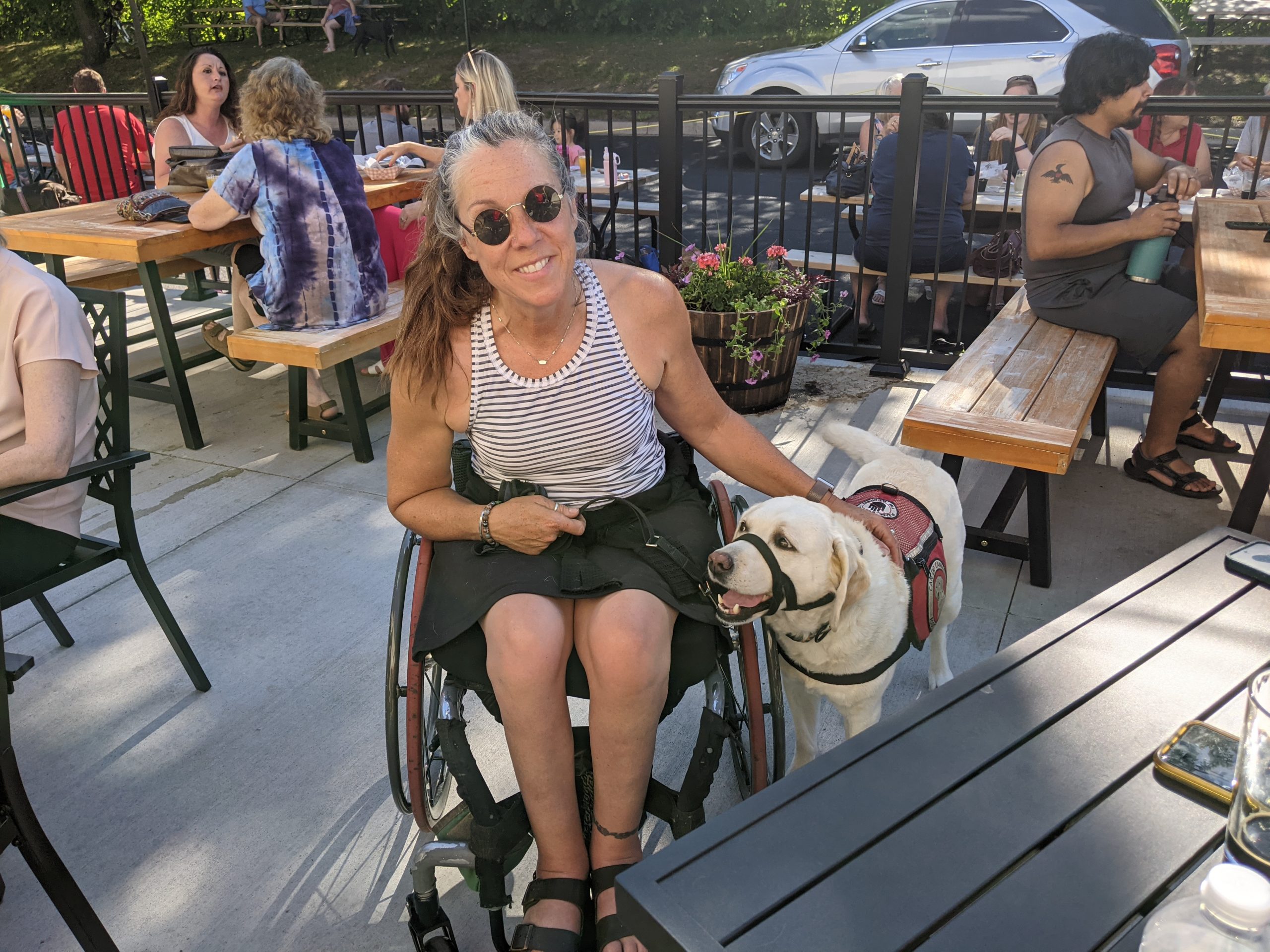 woman in a wheelchair with a service dog next to her