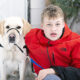 boy in red jacket and white dog sitting on front steps