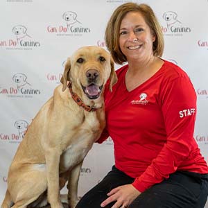 Can Do Canines staff member posing with a yellow lab.