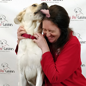 white service dog licking woman's head