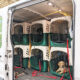 open van door to show dogs inside in crates, with dog photo on van's side