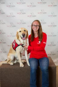 Can Do Canines staff member posing with a Golden Retriever.