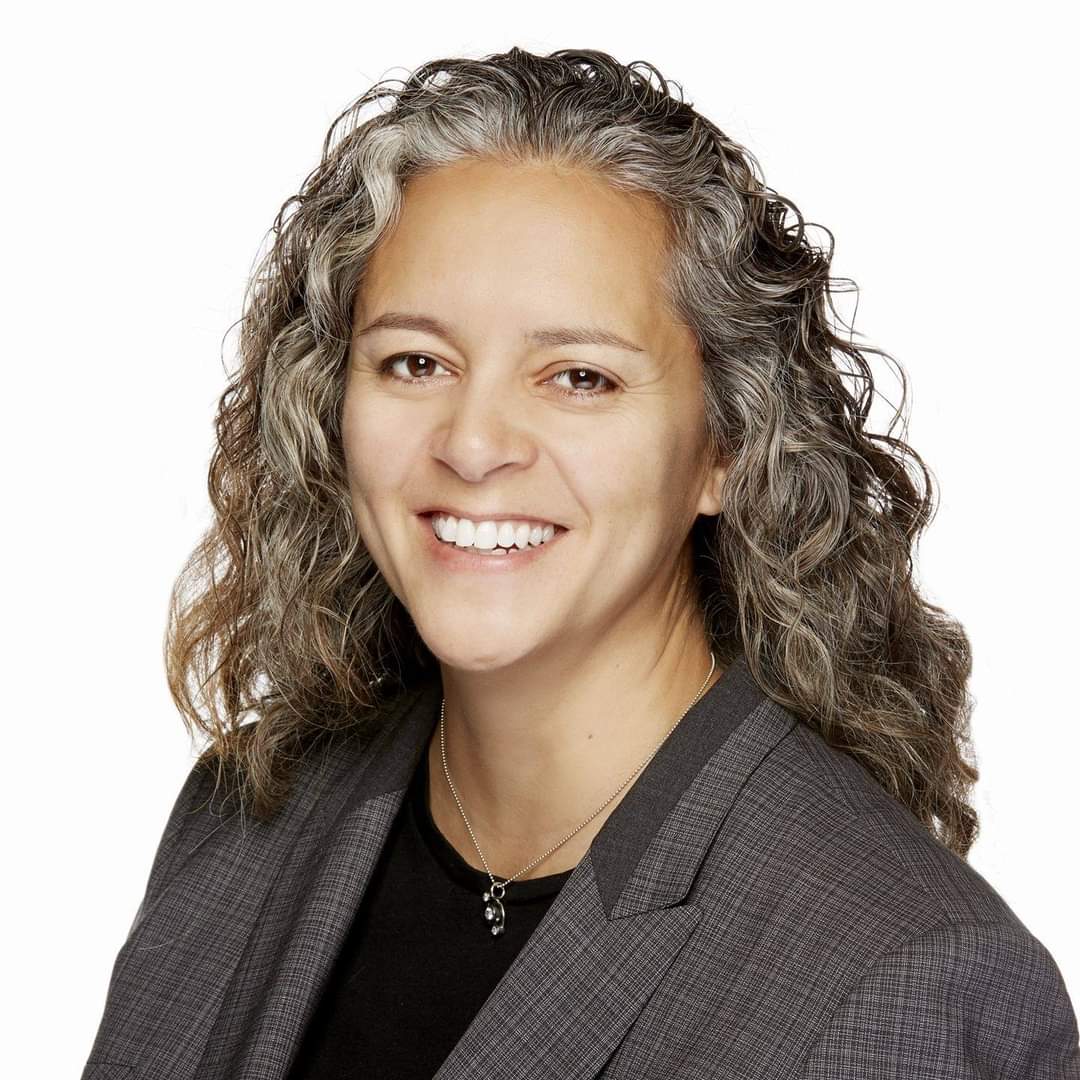 Photo of woman with curly hair smiling at the camera