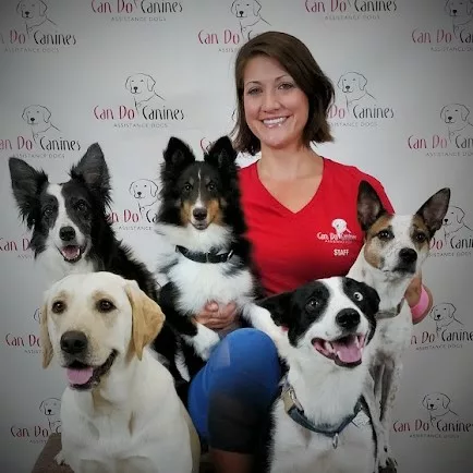 Photo of a woman posing with five dogs.