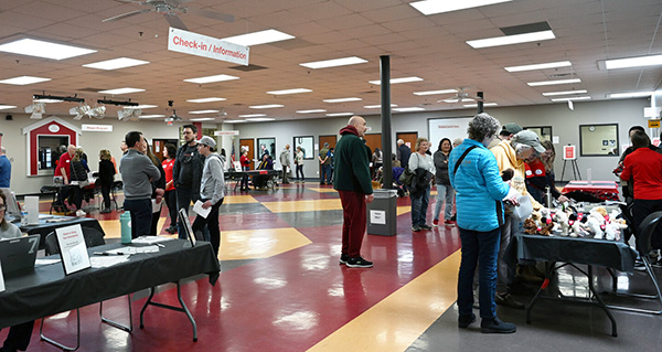 crowd of people in multi-purpose room milling around