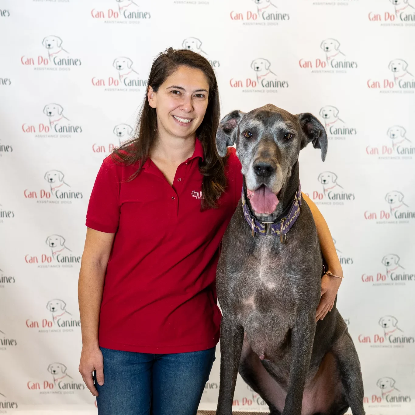 woman standing next to a great dane.